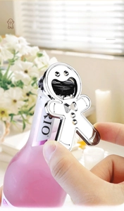 Detail of chrome gingerbread man opener lifting a bottle cap in a bright home setting