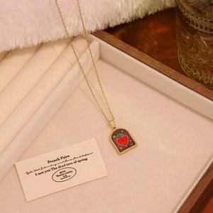 Vintage gold necklace with purple enamel heart pendant displayed in a luxury wooden box
