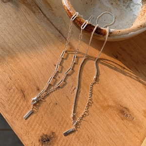 Macro detail of S925 sterling silver chain necklace on ceramic bowl with shadows