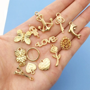 Detailed view of assorted gold DIY charms featuring anchor, owl, and rose for jewelry making