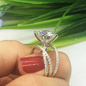 Classic silver crossover ring with four-prong cubic zirconia worn on a finger