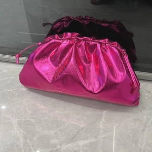 Detail of fuchsia metallic cloud bag with drawstring closure and soft pleated texture