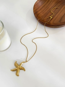 Detail of 18k gold plated starfish pendant with textured scales on a delicate box chain