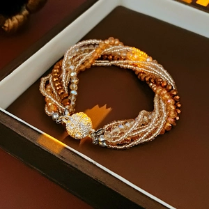 Détail d'un bracelet multi-rangs en perles de cristal champagne avec fermoir magnétique doré