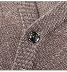 Detailed close-up of a black button and fine knit texture on a brown V-neck cardigan vest
