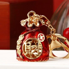 Detailed view of lucky red money bag keychain with golden 'Cai' character and enamel finish