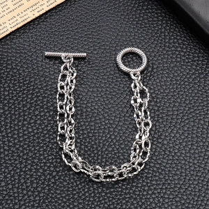 Detail of silver double-layer stainless steel chain bracelet with a vintage OT toggle clasp