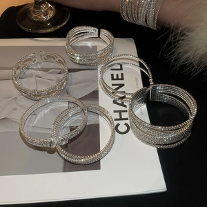 Detail of silver layered rhinestone bracelets on a black velvet background