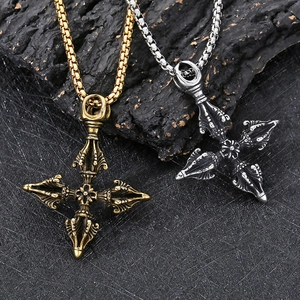 Macro view of gold and silver Buddhist Dorje pendants on a burnt wood texture background