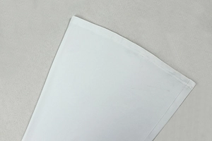 Detail view of clean stitching on the white long sleeve jumpsuit fabric texture