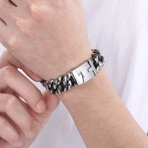 Close-up of men's chunky silver Cuban link bracelet with a polished rectangular buckle