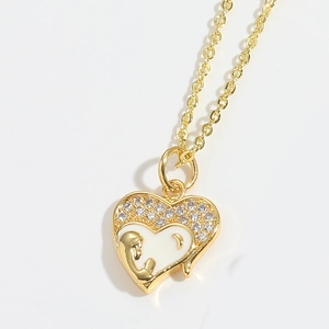 Detail of gold heart pendant with white enamel mother and child motif and zircons