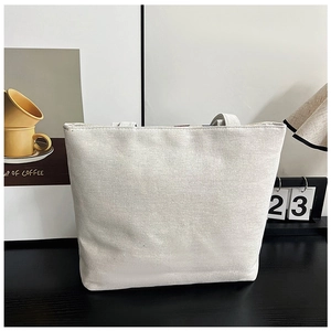 Detailed macro view of ethnic canvas tote bag fabric texture on a lifestyle desk setup