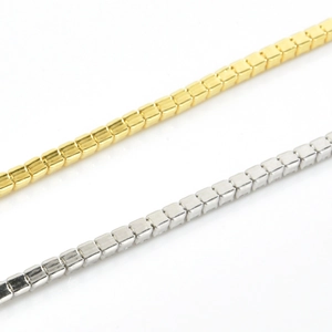 Detailed close-up of geometric cube link chain in polished gold and silver finishes