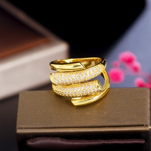 Detailed close-up of a multilayer gold ring with zircon flower and pearl on a jewelry box