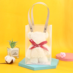 Close-up of white plush bear towel in a frosted gift bag with red 'Just for you' ribbon