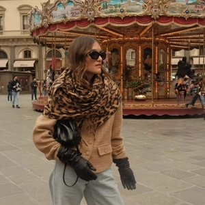 Fashionable tweed jacket paired with leopard print scarf in a vintage street setting