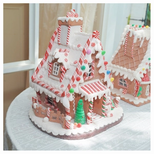 Macro shot of a light-up gingerbread house ornament with snowy resin details and candy colors