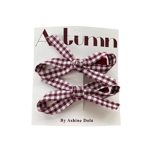 Set of two burgundy plaid handmade ribbon bow hair clips on a white card display