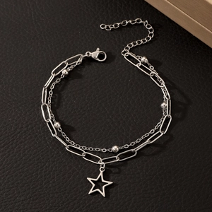Detail of silver double-layered chain bracelet with star pendant and metallic beads