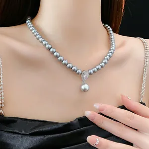 Elegant grey pearl necklace with a teardrop zircon pendant shown on a female model