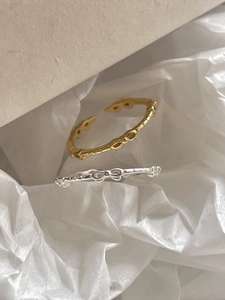 Detail of minimalist 925 sterling silver bow rings in gold and silver adjustable design