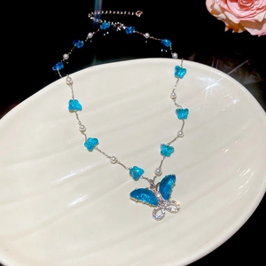 Detalle del collar de mariposa azul con cristales brillantes y perlas de vidrio