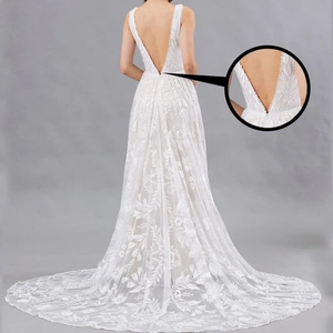 Elegant white lace wedding dress featuring a deep V back and long trailing floral embroidery