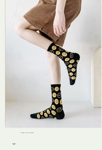 Detail view of black crew socks with yellow smiley face and anti-slip silica gel base