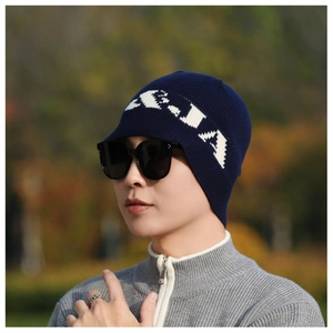 Detail of navy rib-knit beanie with white lettering and classic black square sunglasses