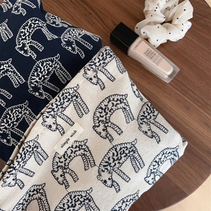 Detail of simple wish cotton canvas pouches featuring giraffe prints and minimalist tags