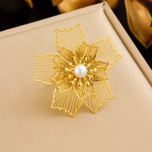 Close-up of gold hollow petal ring with a cream pearl center on textured fabric