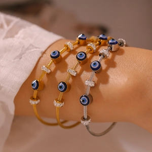 Set of Evil Eye cable bangles in gold and silver finish with blue resin and crystals