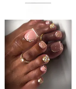 Detailansicht französischer Fußnägel mit Perlen und Kristallen in Nude und Gold