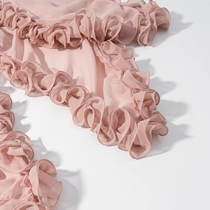 Detail shot of pink ruffled chiffon fabric with elegant layered wave hem textures
