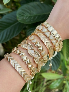 Detailweergave van goudkleurige Boheemse armbanden met hart- en geometrische patronen