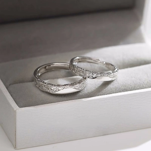 Detail view of silver couple rings with tree bark texture inside a grey velvet jewelry box