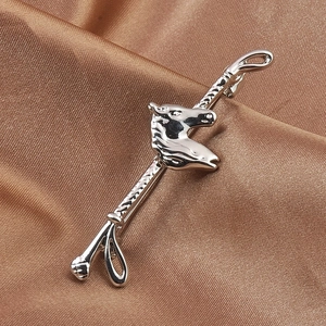 Silver horse head lapel pin on dark silk background with a focus on realistic texture