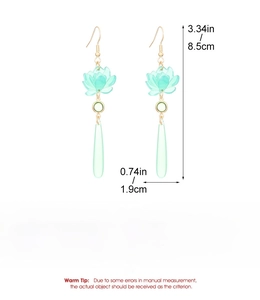 Detail view of light green lotus blossom earrings with elegant long floral drop design