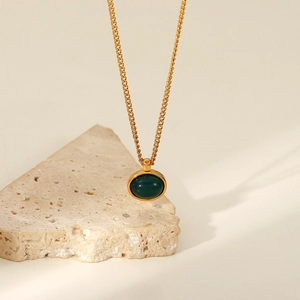 Detailed close-up of 18K gold-plated oval green stone pendant on a minimalist chain