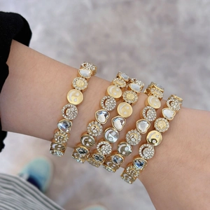 Elegant gold-tone bracelet featuring smiley face, sunflower, and heart crystal charms