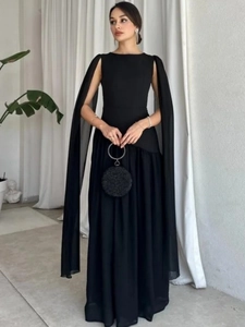 Detail of elegant black evening gown featuring cape sleeves and floor-length silhouette