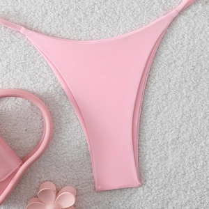 Detail of pink bikini bottom on white faux fur with matching pink floral accessories