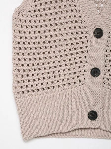 Detailed close-up of beige knit vest featuring hollow crochet texture and black resin buttons