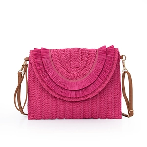 Detailed close-up of woven raffia texture and vibrant fuchsia fringe on the crossbody bag