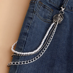 Detail showing multi-layer silver metal pants chain with white pearls and skull pendant