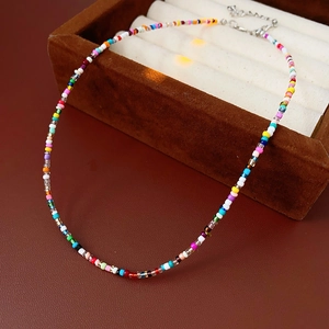 Macro view of colorful glass seed beads with metal lobster clasp and extension chain