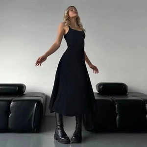 Détail d'une robe midi noire en maille montrant la coupe ajustée et le tissu drapé lisse