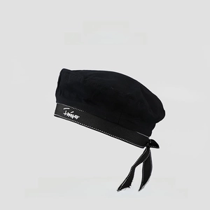 Close-up of black beret with Forever embroidery and a white stitched ribbon bow