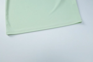 Vue détaillée de l'ourlet de robe vert menthe avec coutures doubles plates et soignées